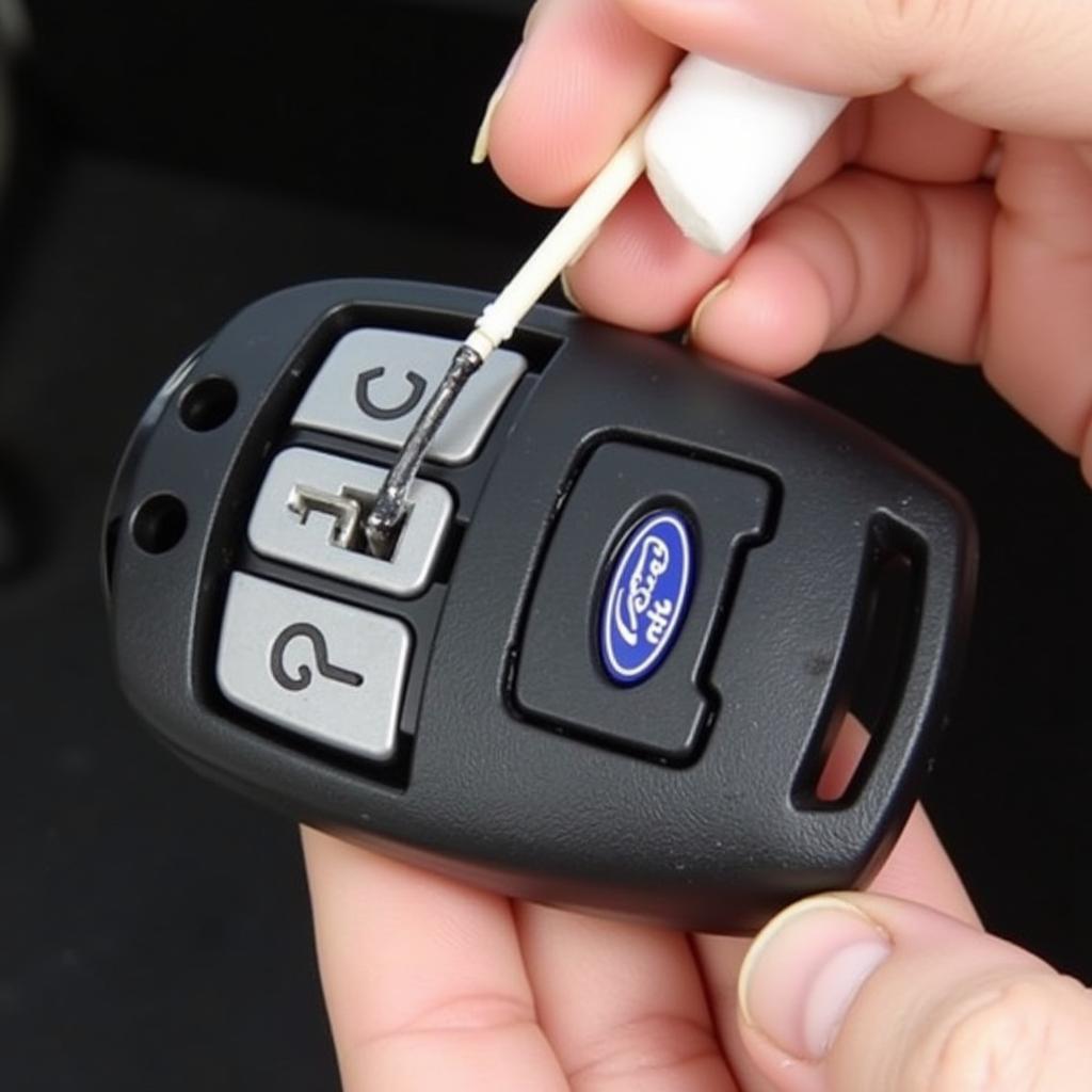 Cleaning 2013 Ford Key Fob Battery Contacts with Cotton Swab and Rubbing Alcohol