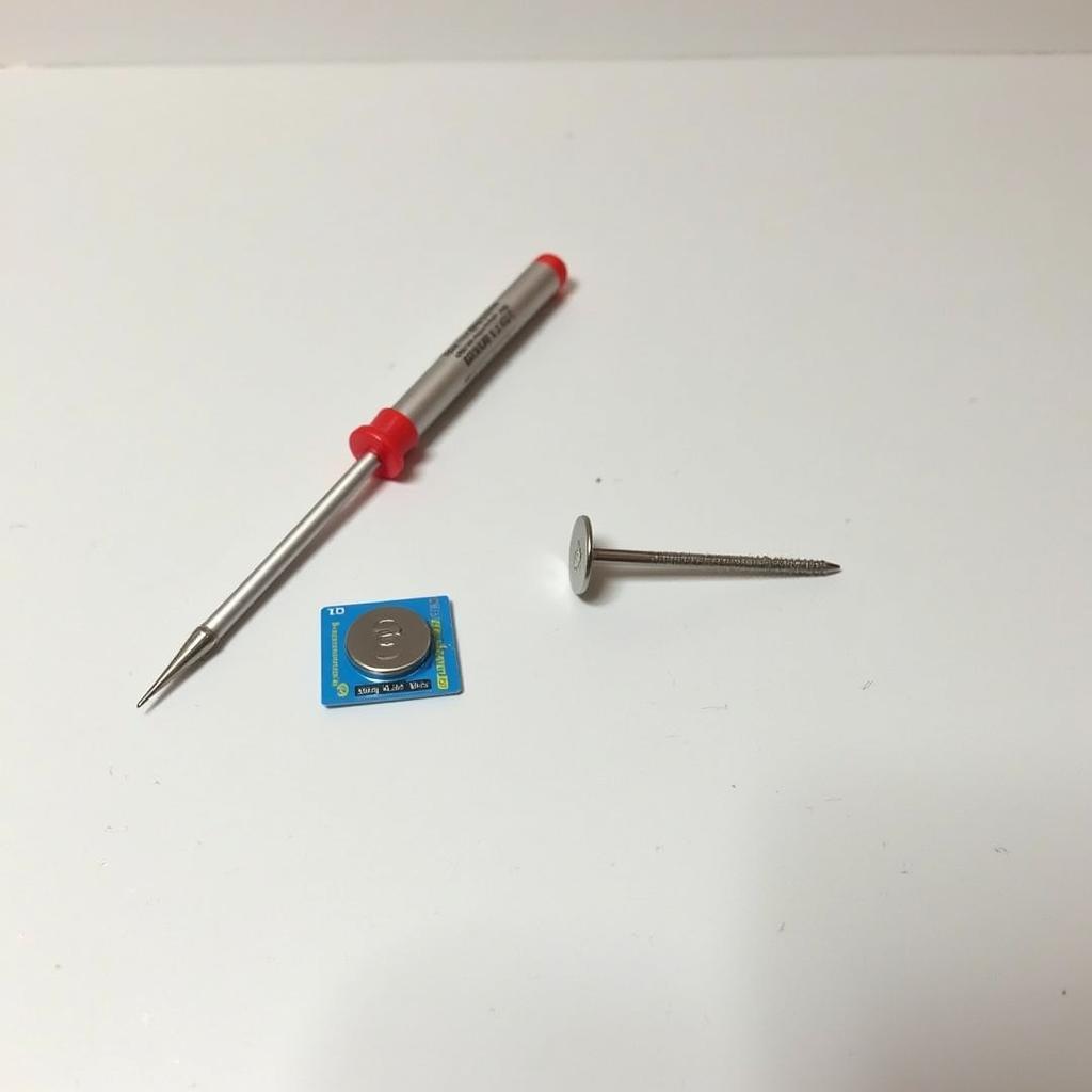 CR2032 Battery and Flathead Screwdriver on a Table