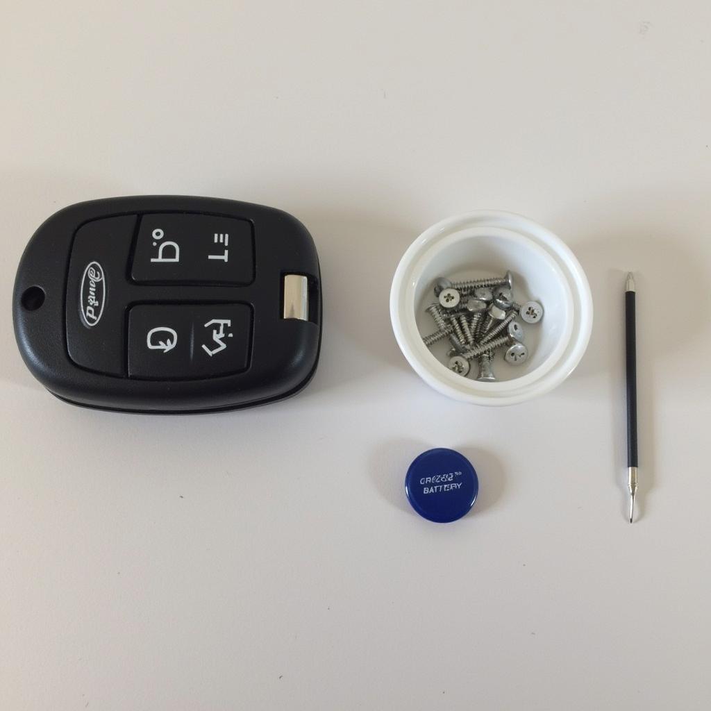 Essential tools for replacing a Ford key fob battery including a CR2032 battery and a flathead screwdriver.