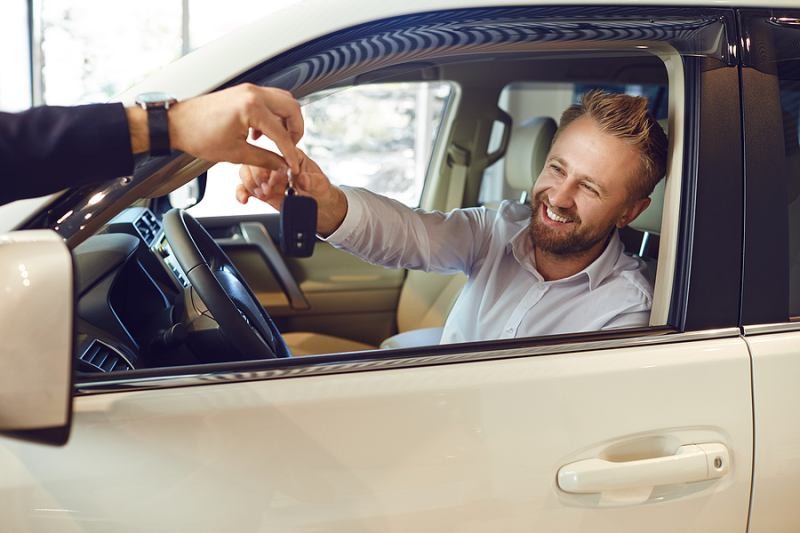 Hand holding a modern car key fob, illustrating common issues that lead to key fob failure and the need for replacement.