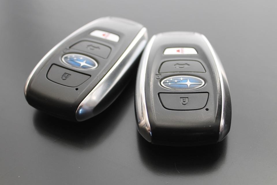 Using a car key fob to start a vehicle, illustrating keyless ignition technology.