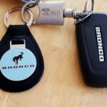 Dealership branded key fob keychain in Cactus Gray color, illustrating a simple and brand-affiliated accessory.