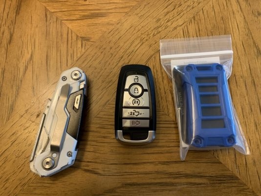 Ford Raptor original key fob next to AJT Designs injection molded key fob case, showcasing the upgrade