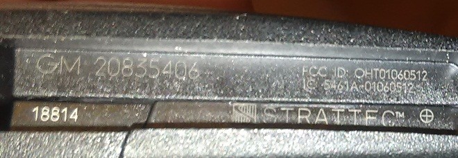 Close-up view of the FCC ID OHT01060512 location on a 2013 Chevy Malibu key fob, essential for determining key compatibility and successful programming.