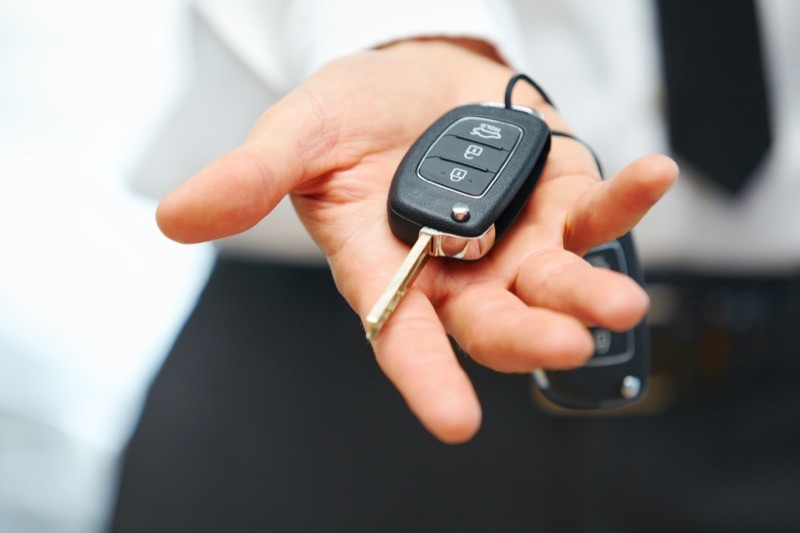 A modern car key fob with lock, unlock, and remote start buttons