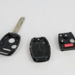 Disassembled components of a car key fob, revealing the internal circuit board and battery housing.