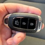 Modern car key fob and keys on a wooden surface