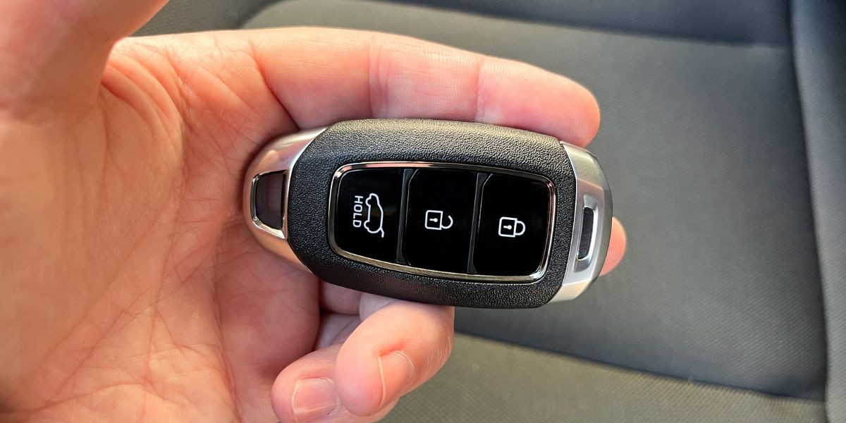 Modern car key fob and keys on a wooden surface