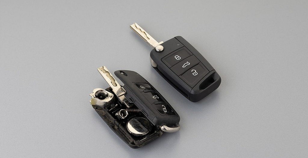 Replacing the battery in a car key fob, showcasing the common coin cell type and the ease of maintenance for continuous vehicle access.