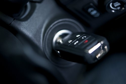 Car key in ignition with key fob buttons for illustrative purposes