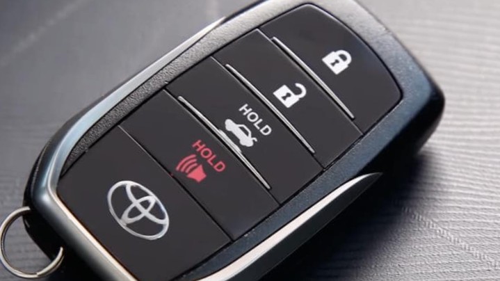 Toyota key fob on a white background, showcasing the location of the emergency key release button.